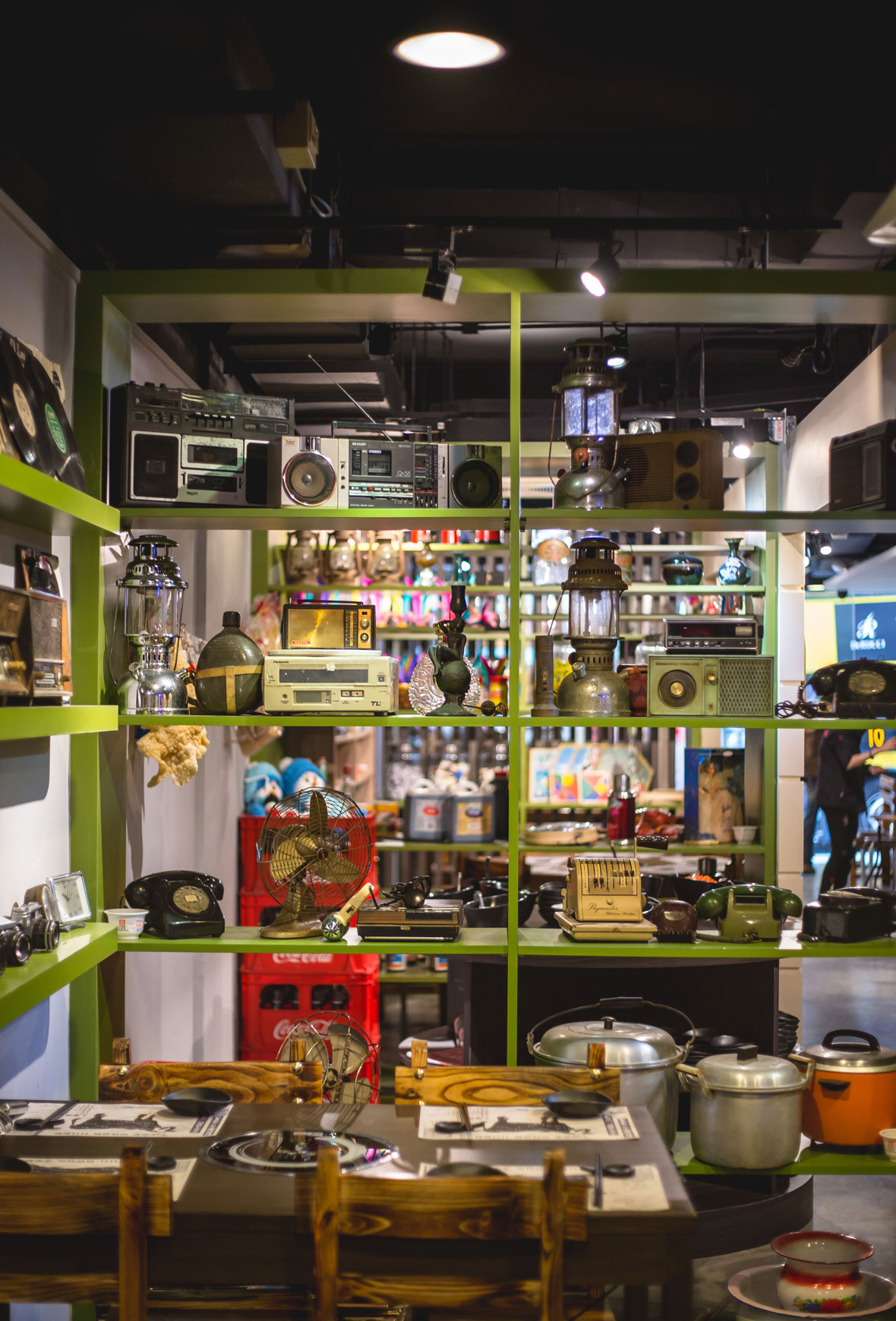 616 Nostalgic Beef Hotpot Restaurant | Round dining table and green display shelving, with nostalgic items mounted on the wall