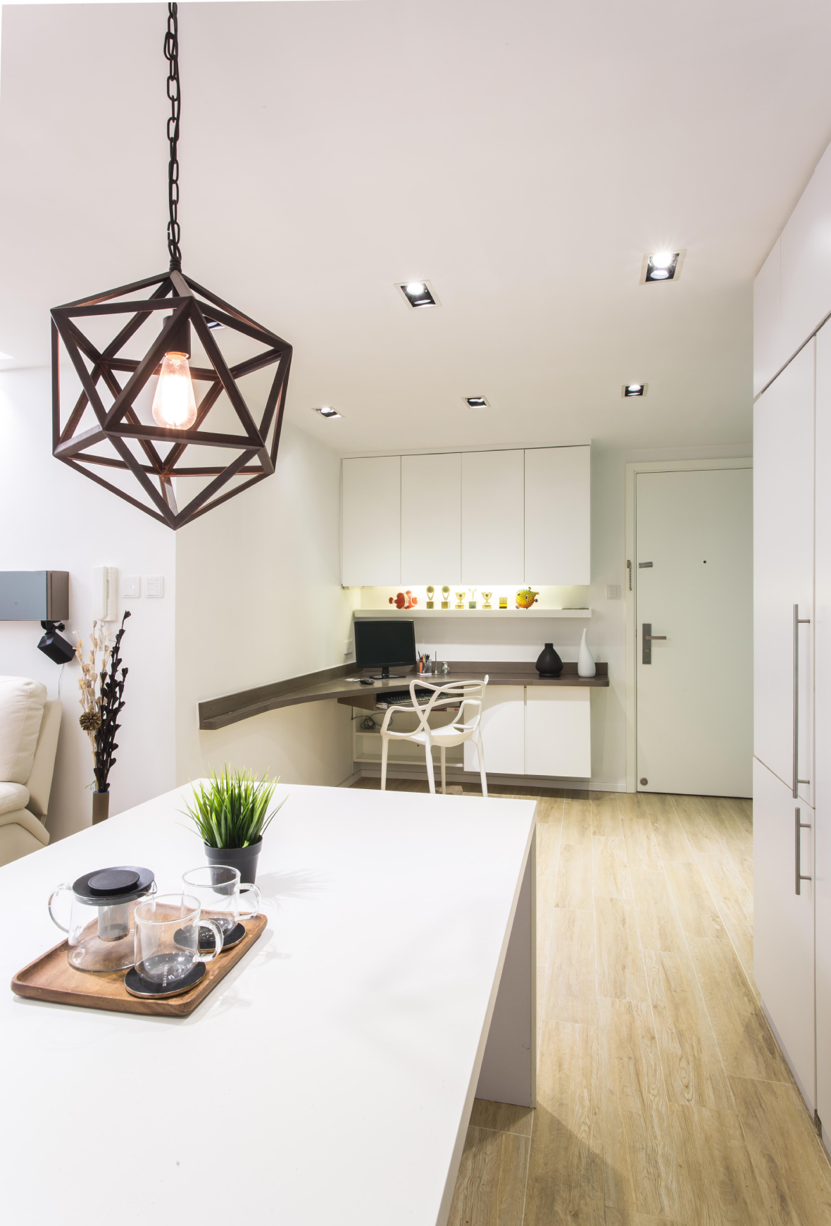 Kitchen space, aqua‑green glass backsplash and white cabinets, distinctive geometric pendant light