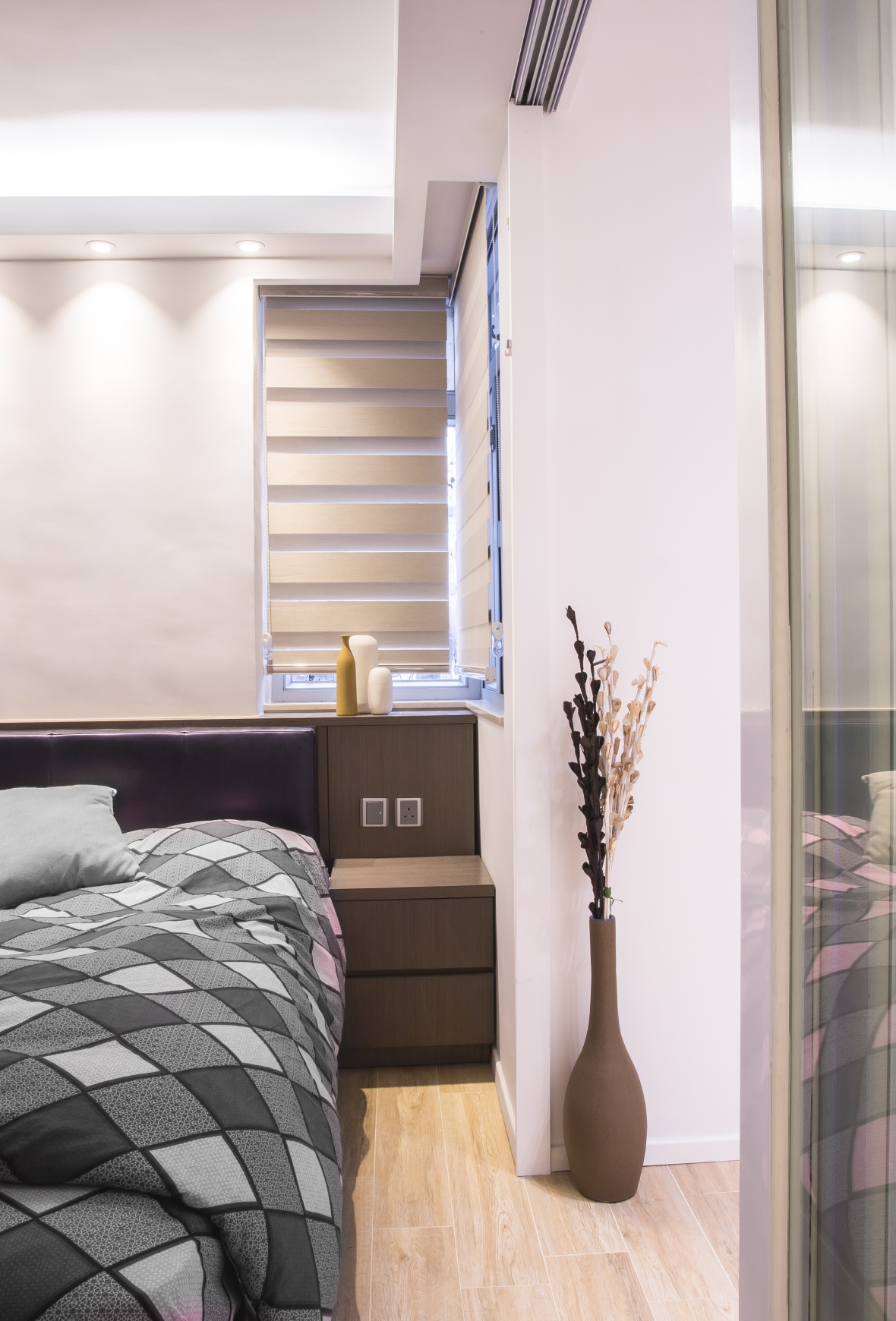Bedroom space, timber platform bed and white wardrobe, large windows providing natural light