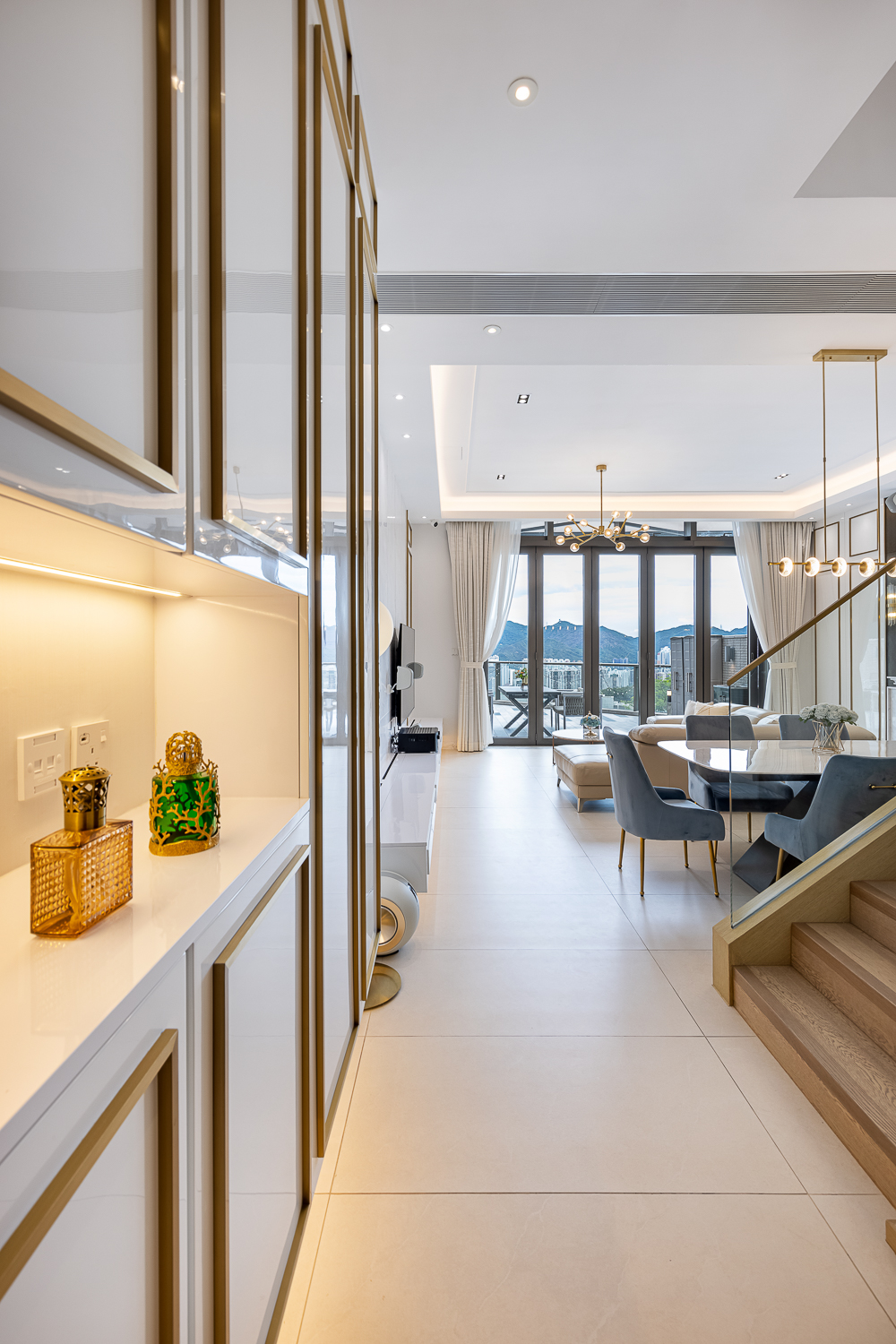 Dining room close‑up: a marble dining table with blue chairs and a gold pendant light