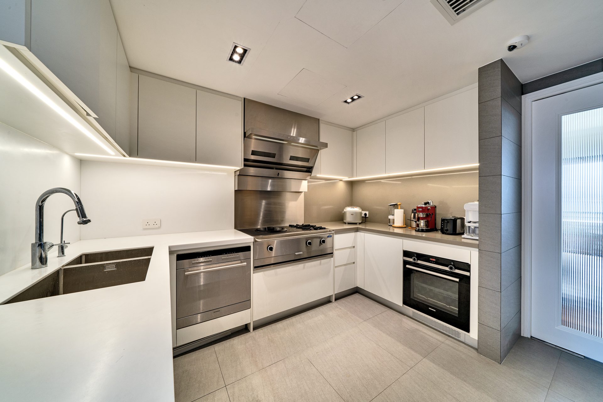 Hong Kong Parkview - — Study with a long wooden desk, white wall‑mounted cabinets and a window‑side seating platform