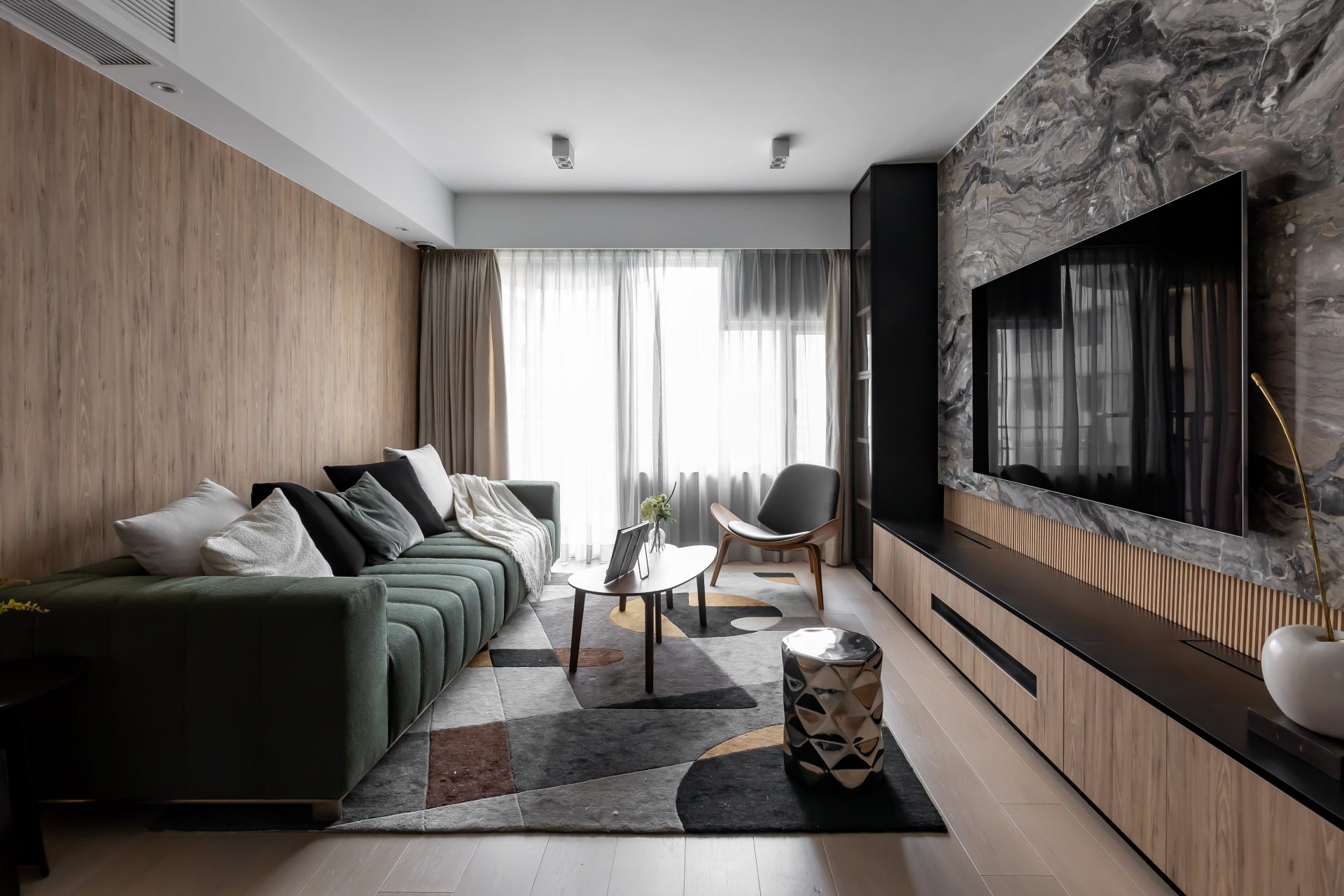 Living room panorama showing the sofa, coffee table and TV wall